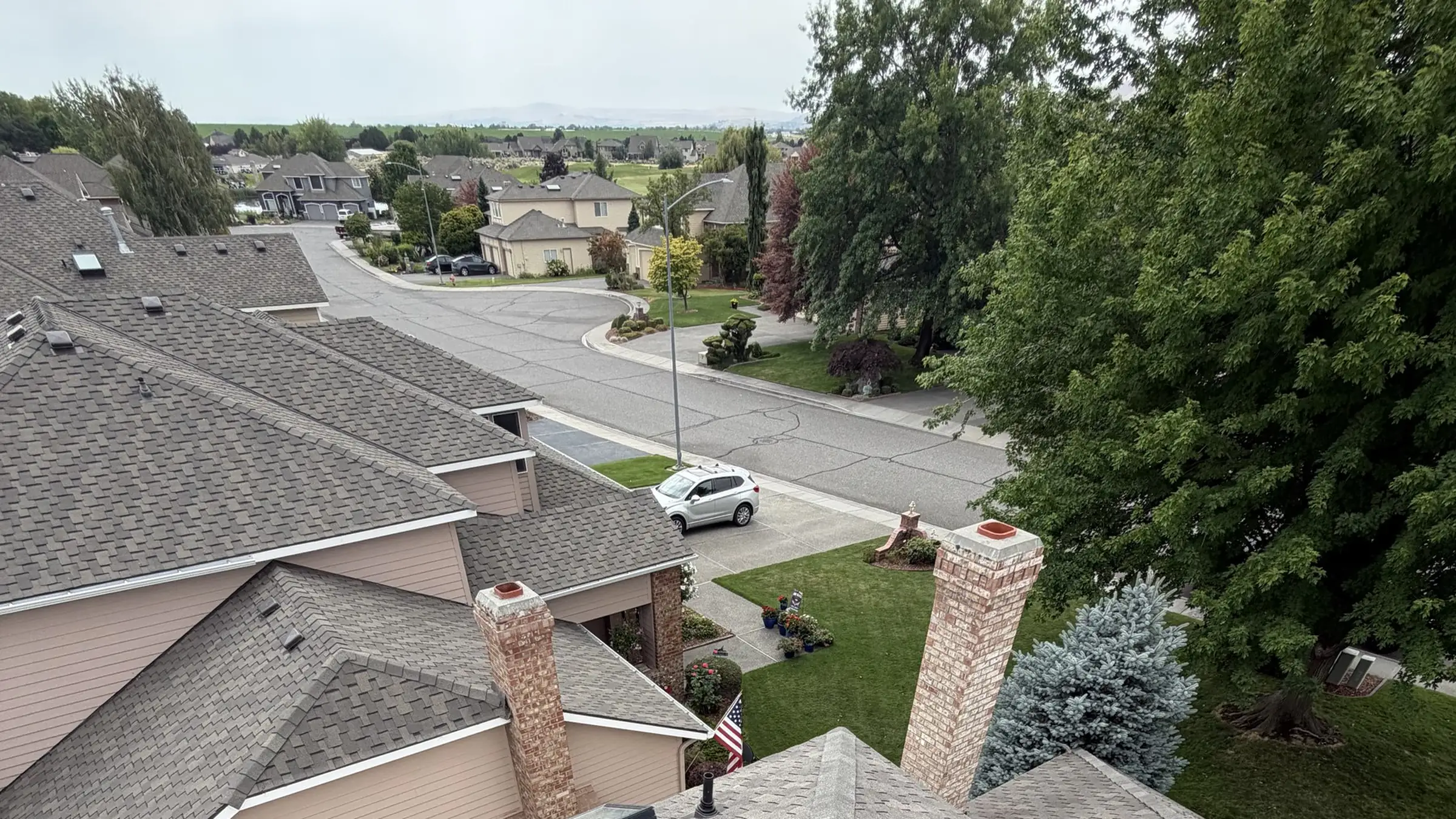 A Tri-Cities street of homes seen from a rooftop, with the valley flattening out to the horizon
