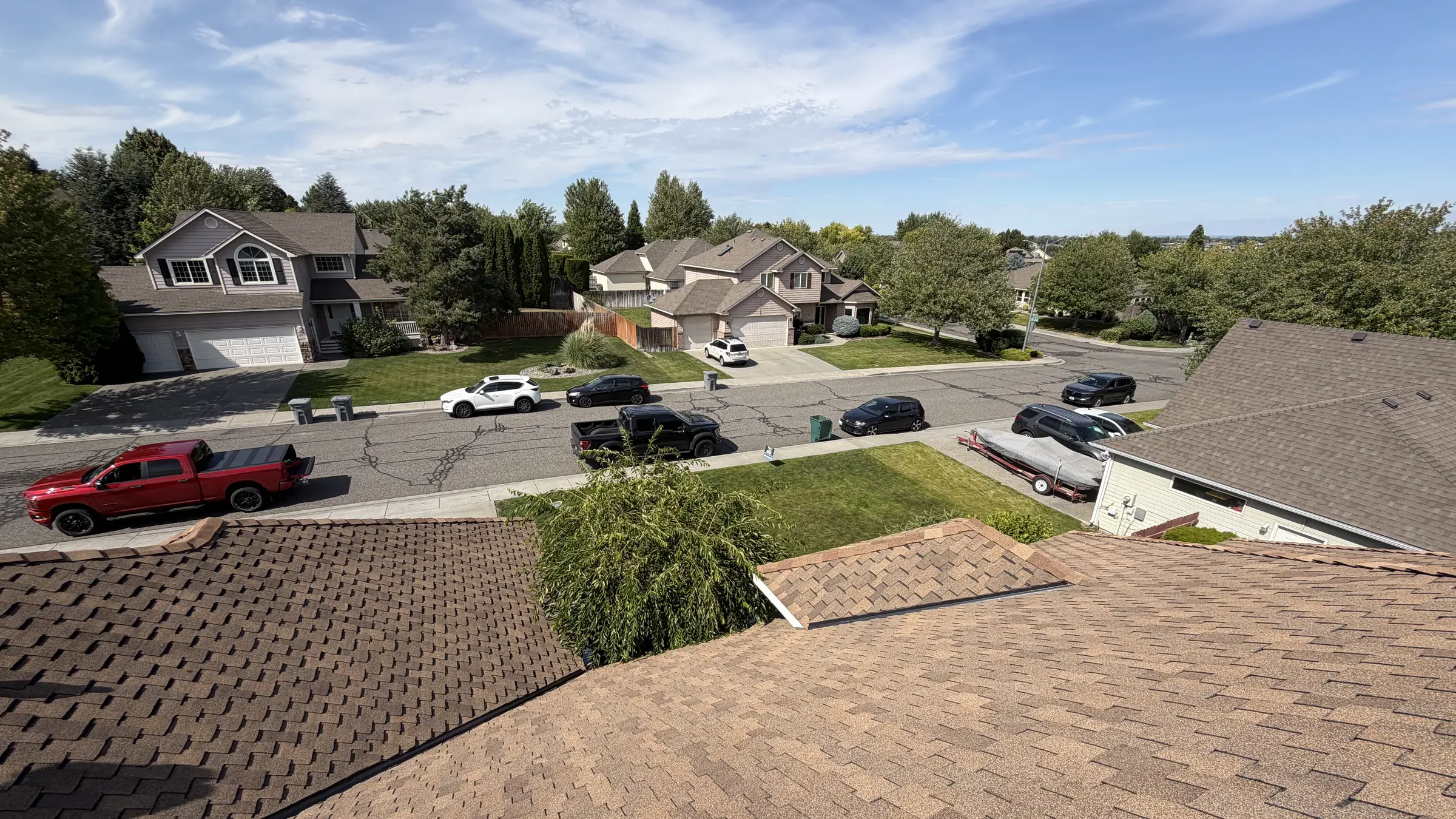 A completed shingle roof in the foreground with a street of finished Eastern Washington homes behind it