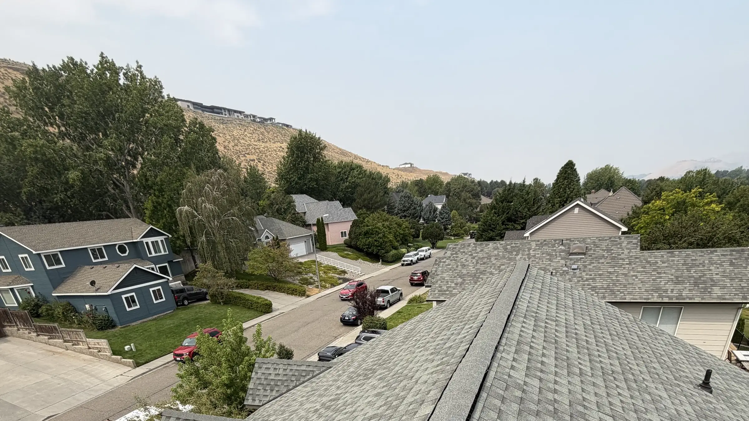 A Richland neighbourhood seen from a finished roof, with the basalt ridgeline on the horizon