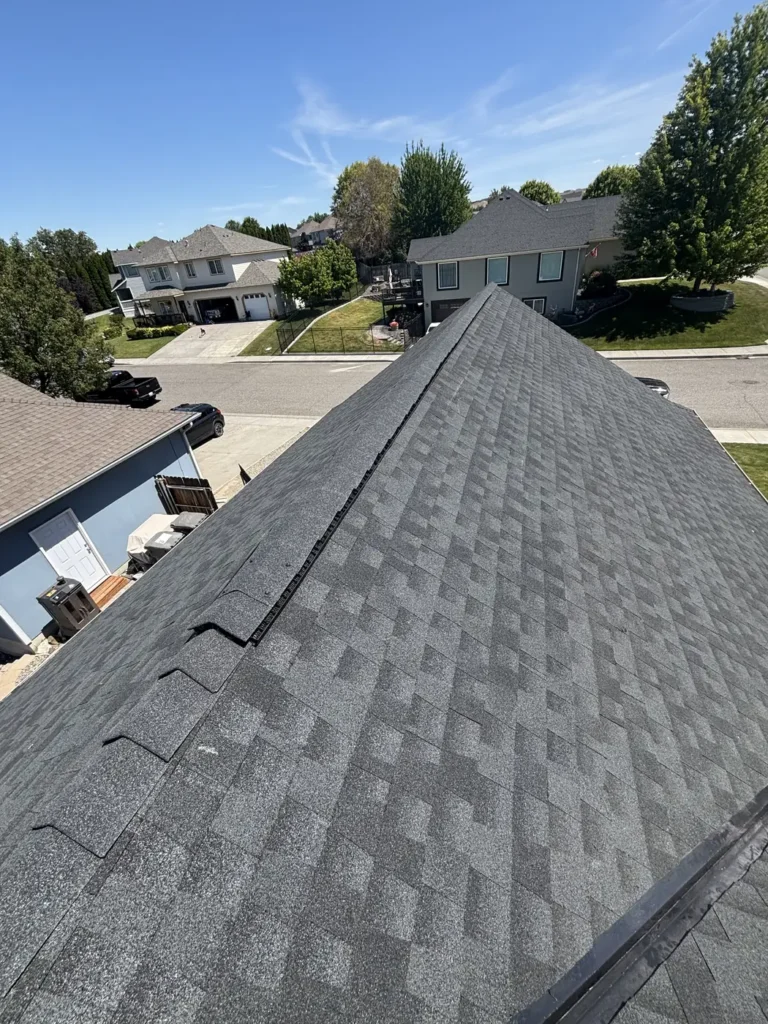 New shingle roof with two-storey homes and a quiet street beyond