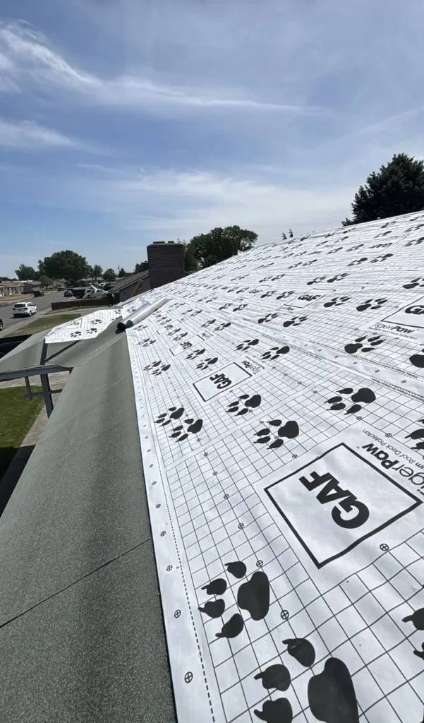 GAF Tiger Paw underlayment going down on the roof deck partway through an installation
