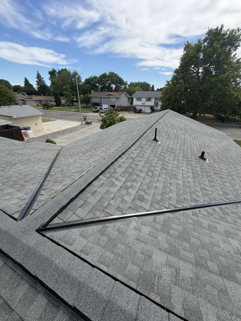 Valley and hip detail on a completed roof, with the neighbourhood beyond