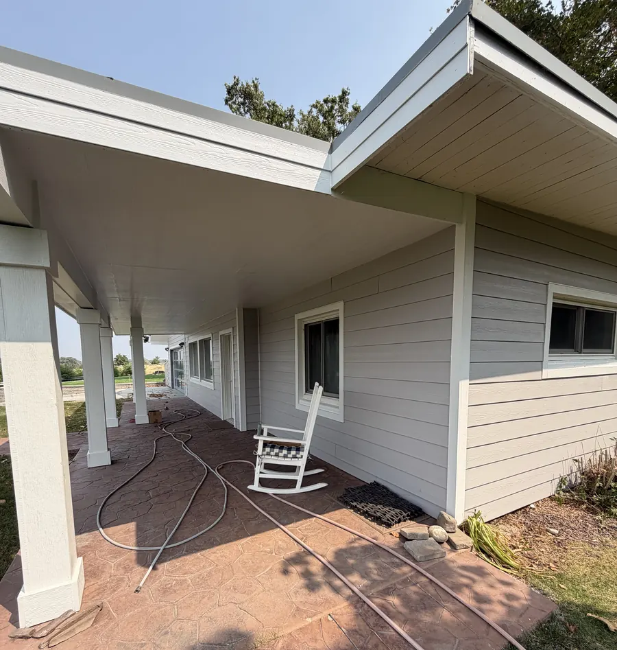 A covered porch and new siding on a completed home exterior